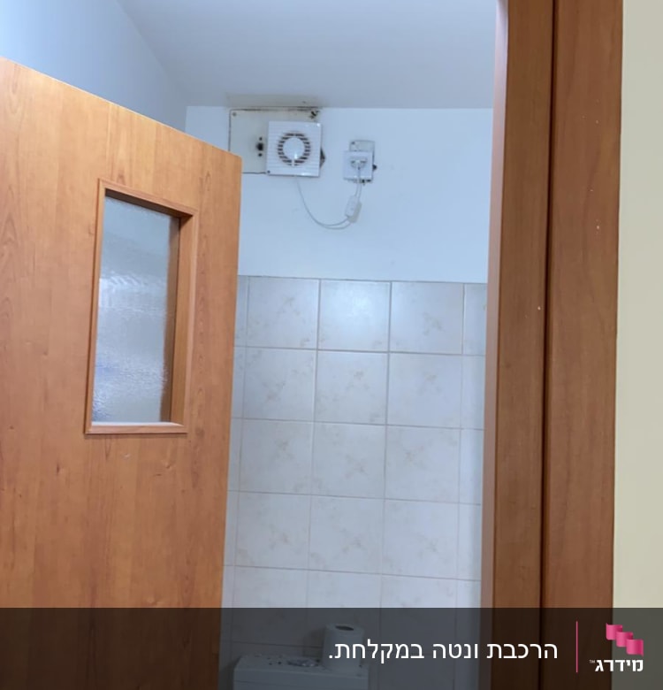 מאוורר קיר ותיבת חיבורים חשמלית בחדר אמבטיה